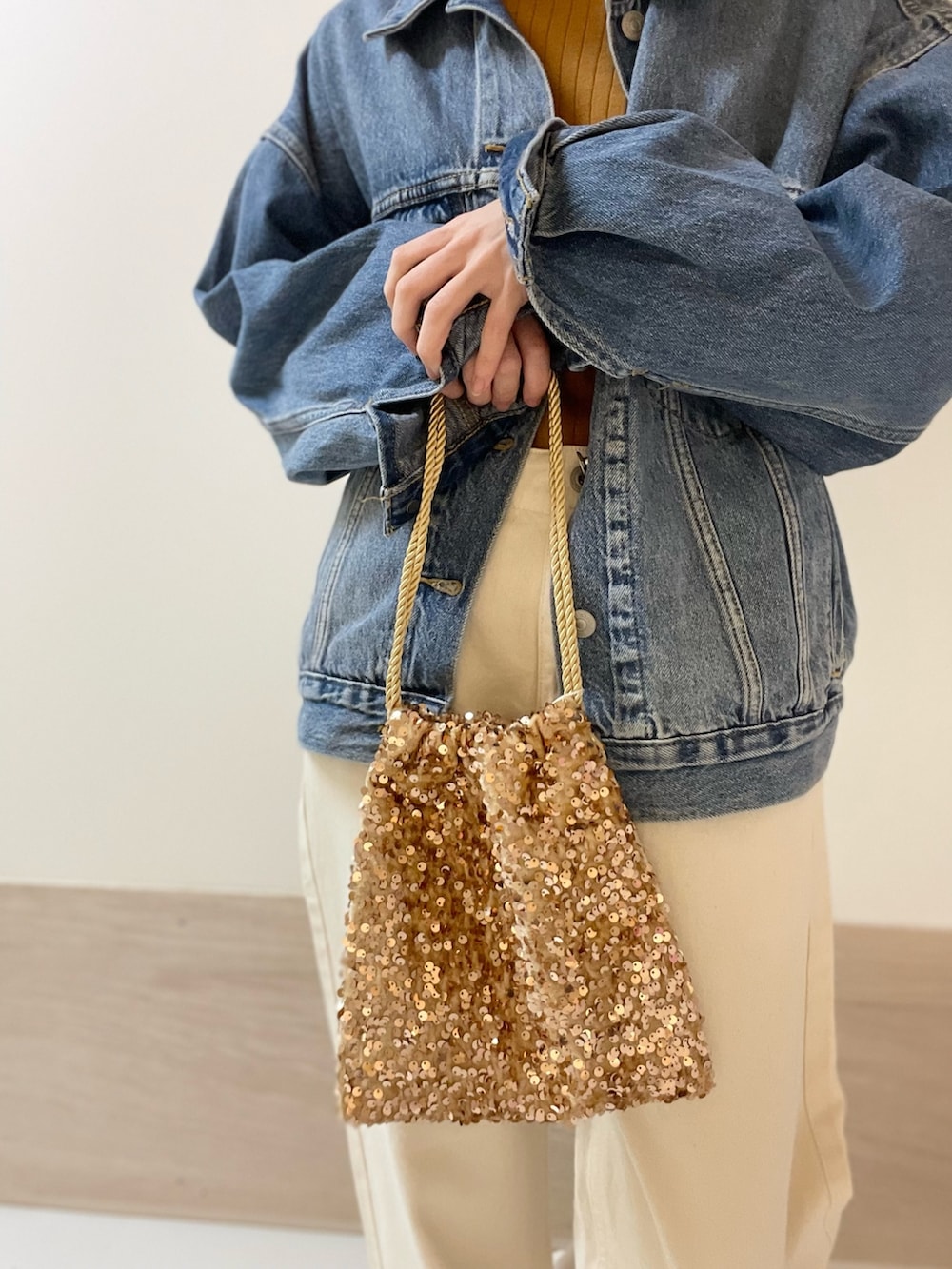 イエロー系のニット/セーター、ベージュ系のデニムパンツ、ブルー系のデニムジャケットを着用したレディースの冬コーディネートの7枚目の写真