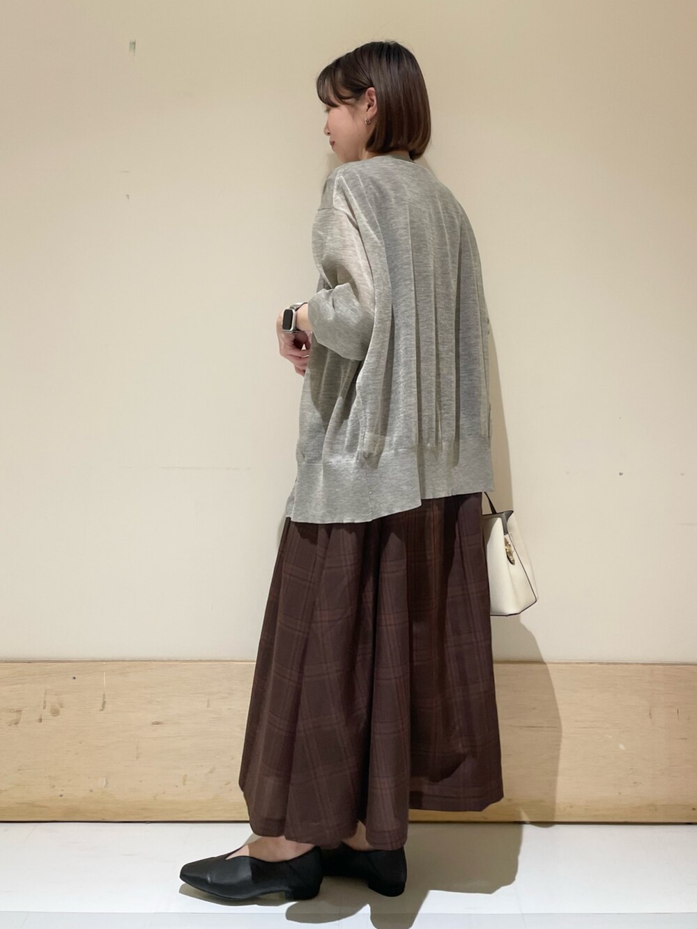 ブラウン系のワンピース、ベージュ系のカーディガン/ボレロ、ブラック系のパンプスを着用したレディースの夏コーディネートの4枚目の写真