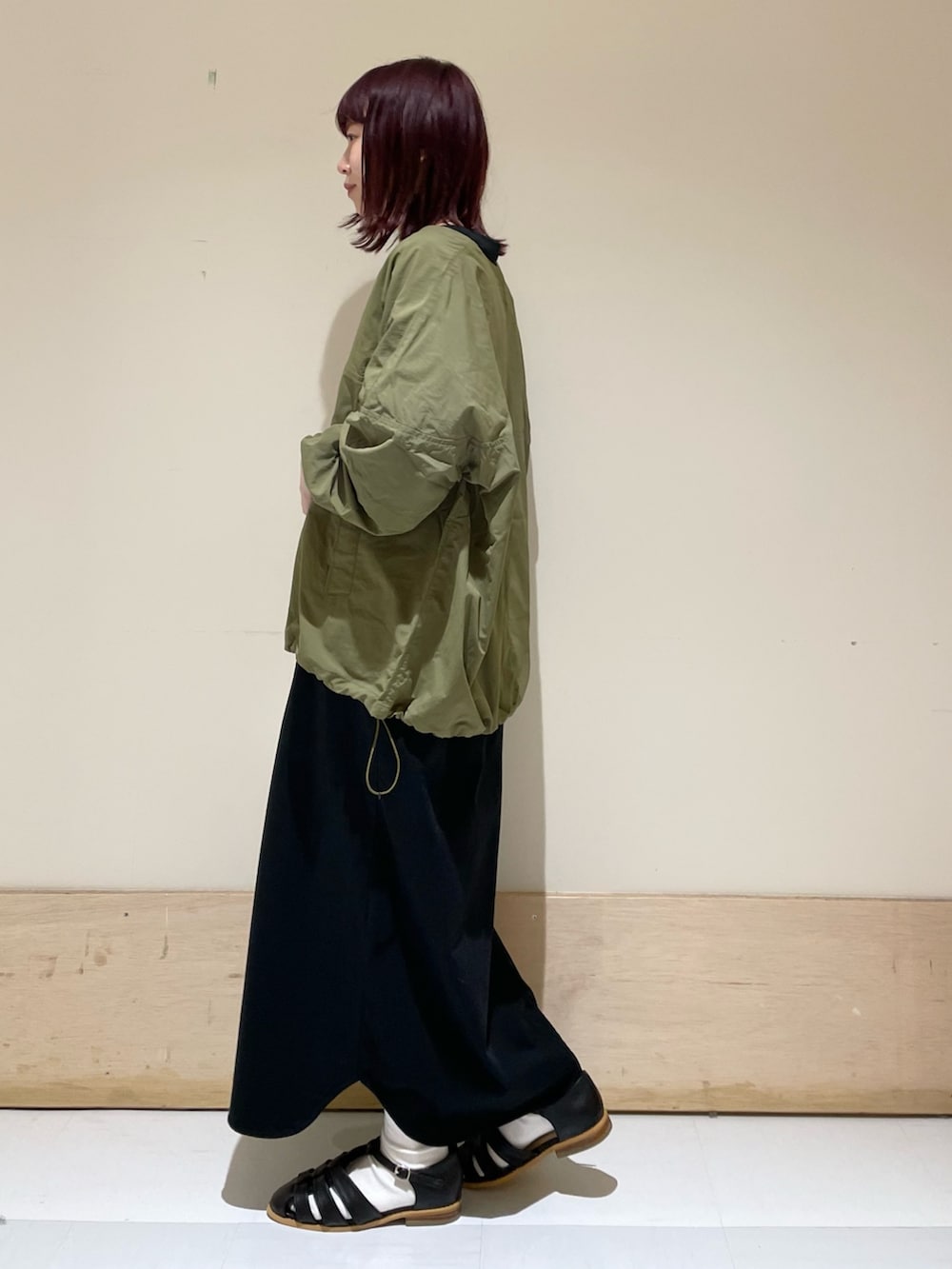 ホワイト系のハンドバッグ、ブラック系のワンピース、グリーン系のその他トップスを着用したレディースの春コーディネートの5枚目の写真