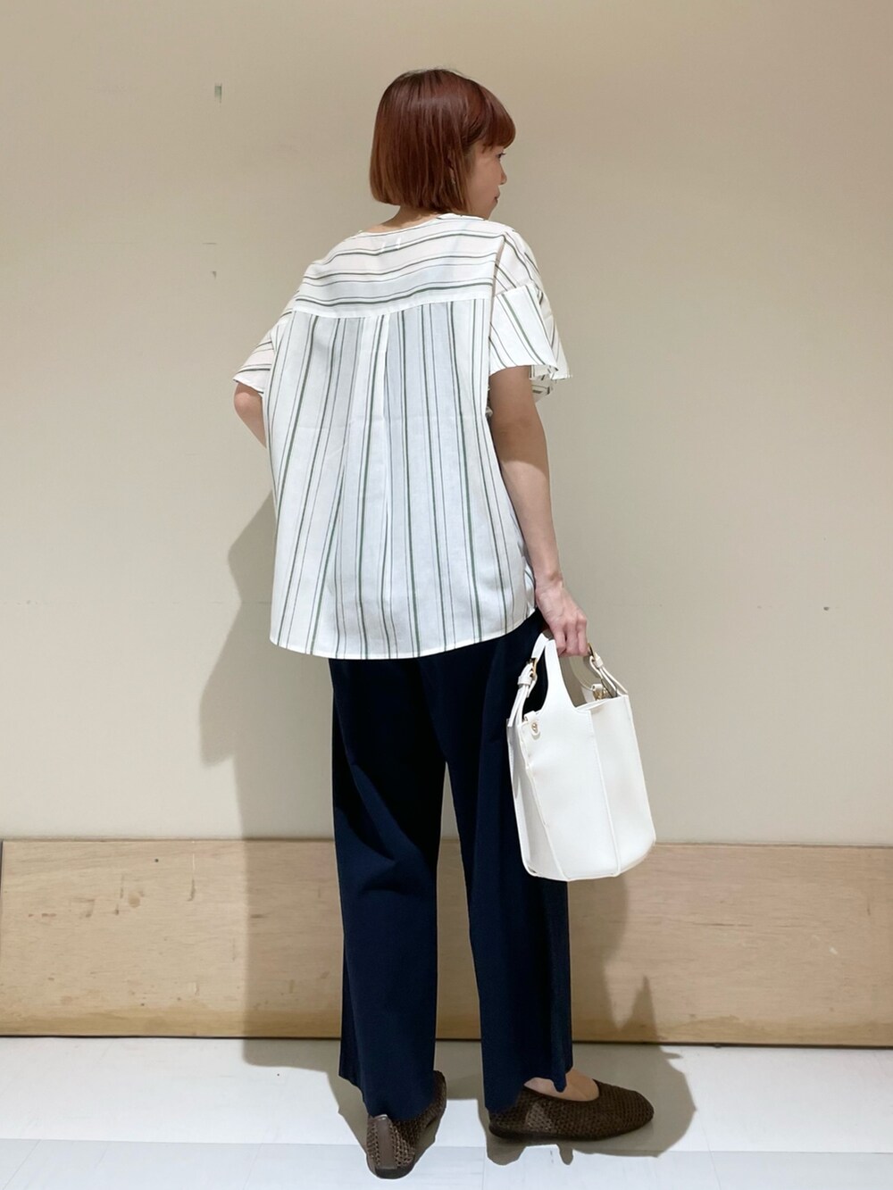 グリーン系のシャツ/ブラウス、ブルー系のその他パンツ、ホワイト系のトートバッグを着用したレディースの春コーディネートの5枚目の写真