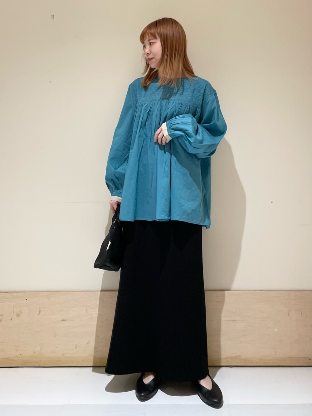 ブルー系のシャツ/ブラウス、ブラック系のスカート、ブラック系のショルダーバッグを着用したレディースの春コーディネートの2枚目の写真