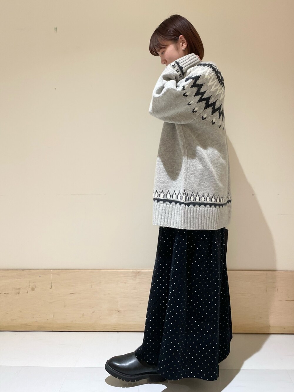 グレー系のニット/セーター、ブラック系のブーツ、ブラウン系のトートバッグを着用したレディースの秋コーディネートの5枚目の写真