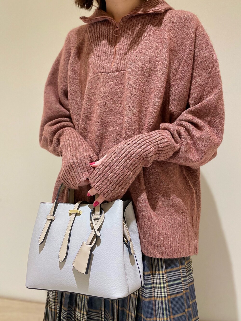 レッド系のニット/セーター、ブラック系のパンプス、グレー系のハンドバッグを着用したレディースの秋コーディネートの8枚目の写真