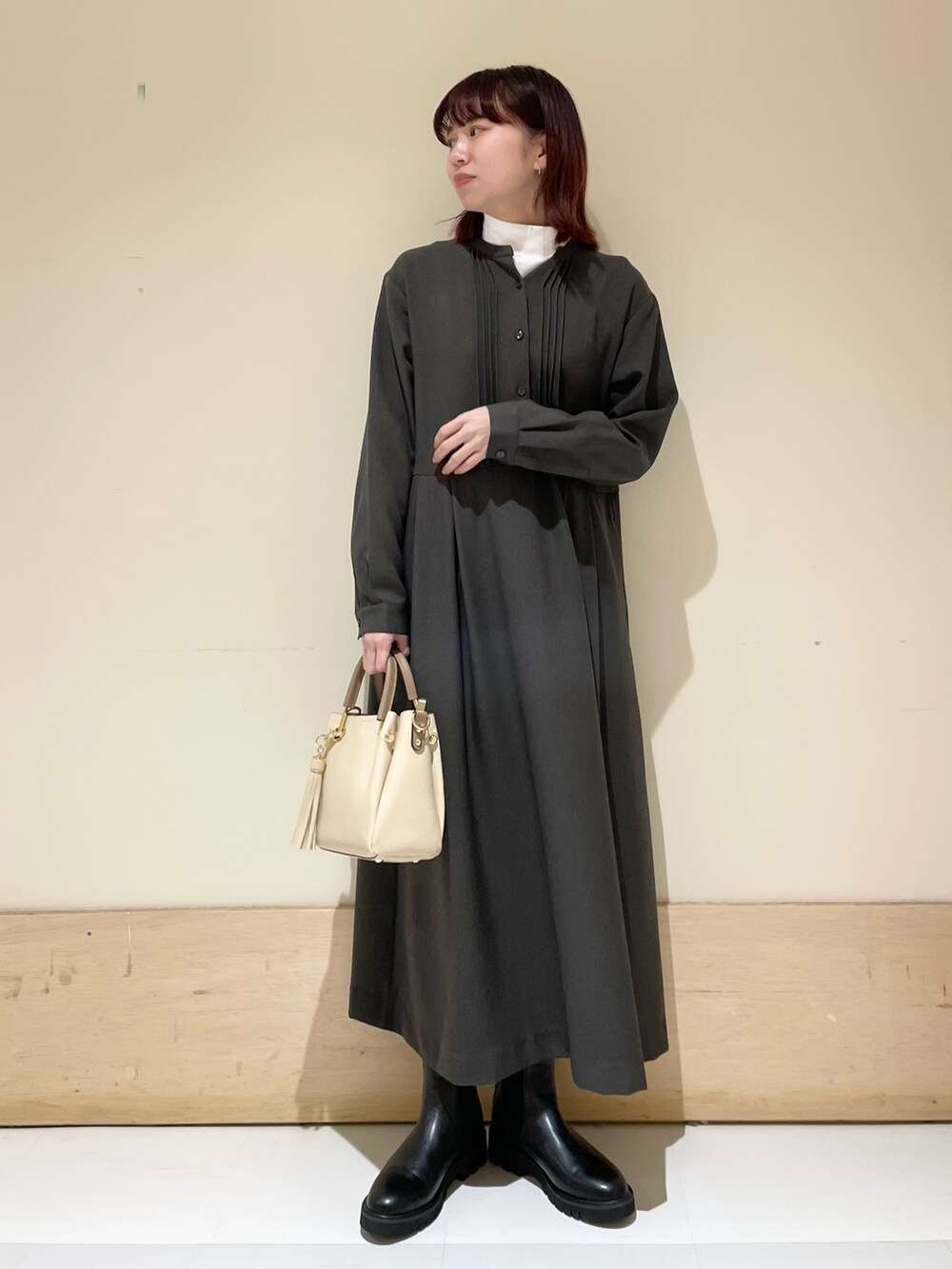 ブラック系のブーツ、グレー系のワンピース、ホワイト系のTシャツ/カットソーを着用したレディースの冬コーディネートの2枚目の写真