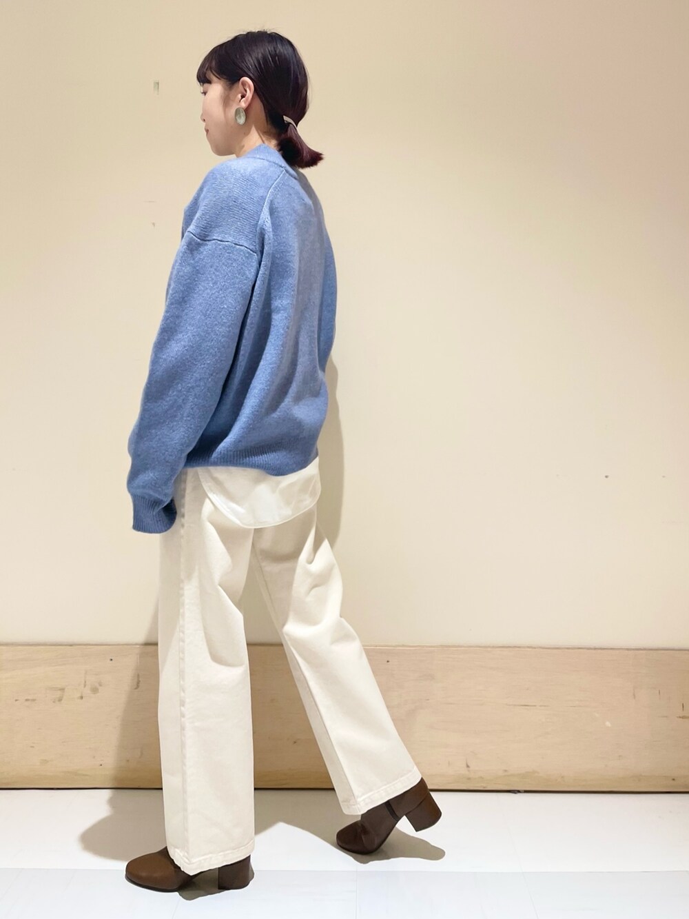 ベージュ系のデニムパンツ、ブルー系のニット/セーター、ホワイト系のショルダーバッグを着用したレディースの冬コーディネートの5枚目の写真