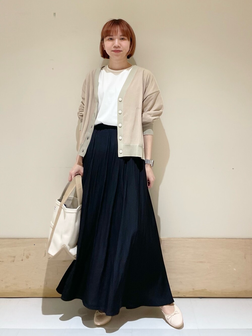 ブラック系のスカート、ベージュ系のカーディガン/ボレロ、ホワイト系のTシャツ/カットソーを着用したレディースの春コーディネートの3枚目の写真