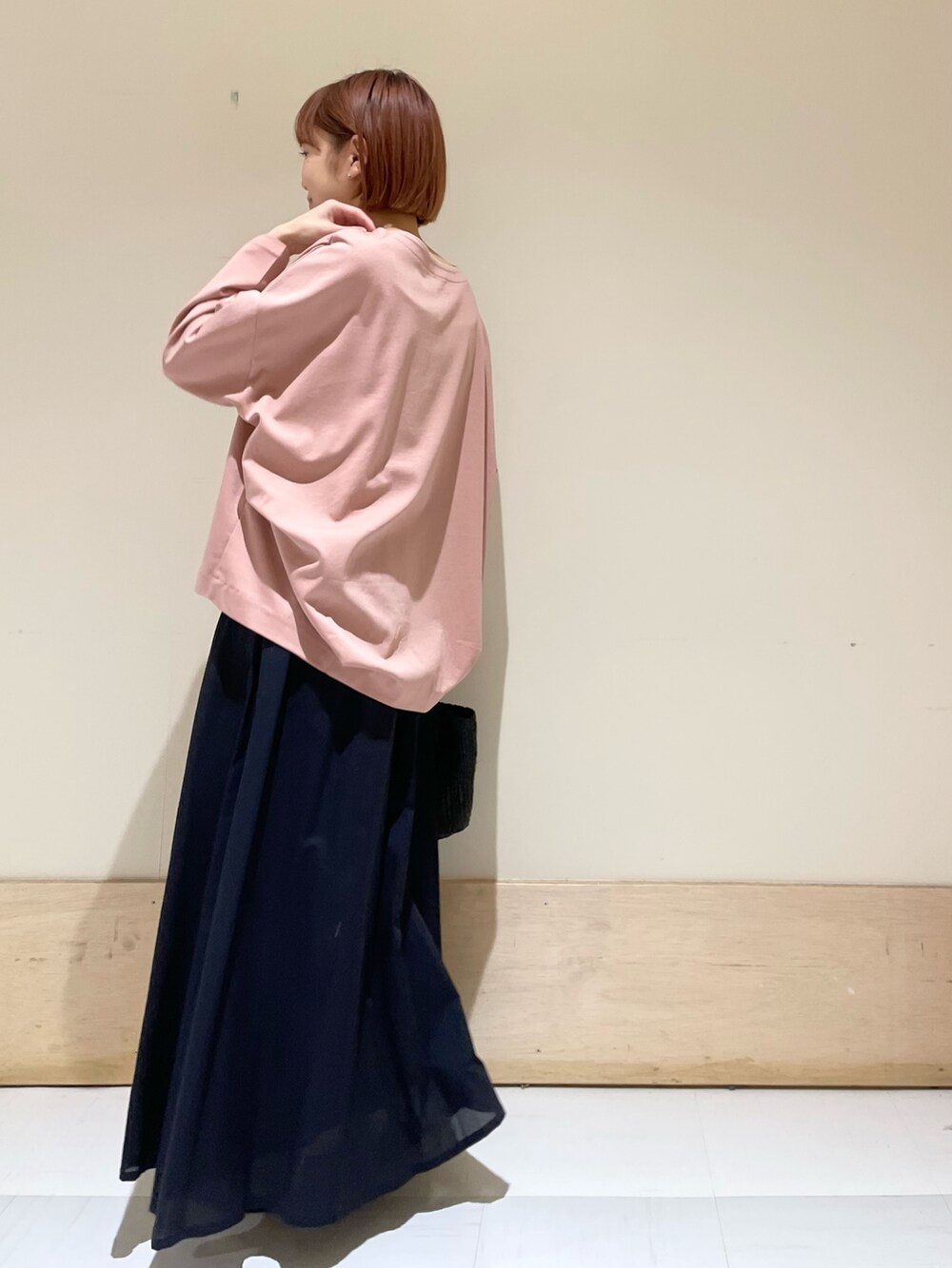 ピンク系のTシャツ/カットソー、ブルー系のスカート、ブラック系のハンドバッグを着用したレディースの春コーディネートの6枚目の写真