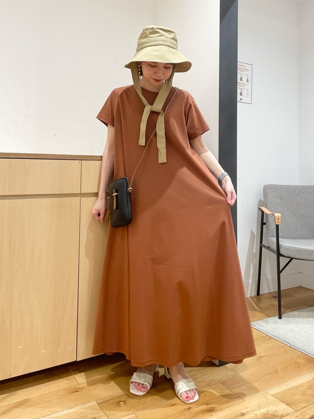 ホワイト系のサンダル、ブラウン系のワンピース、ブラック系のショルダーバッグを着用したレディースの夏コーディネートの4枚目の写真