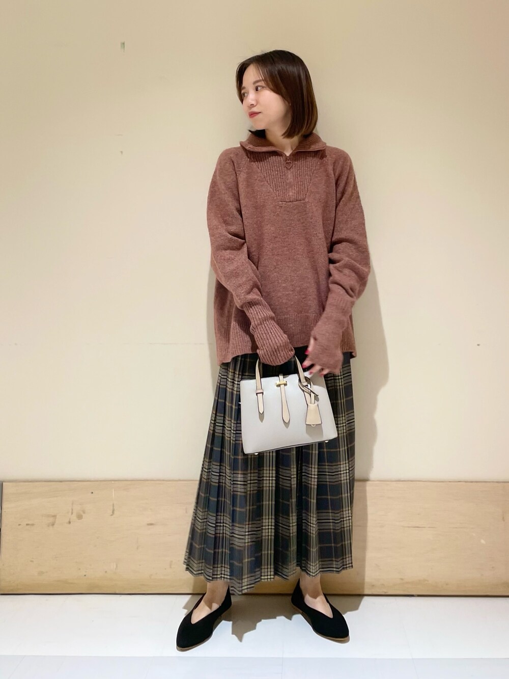 レッド系のニット/セーター、ブラック系のパンプス、グレー系のハンドバッグを着用したレディースの秋コーディネートの3枚目の写真