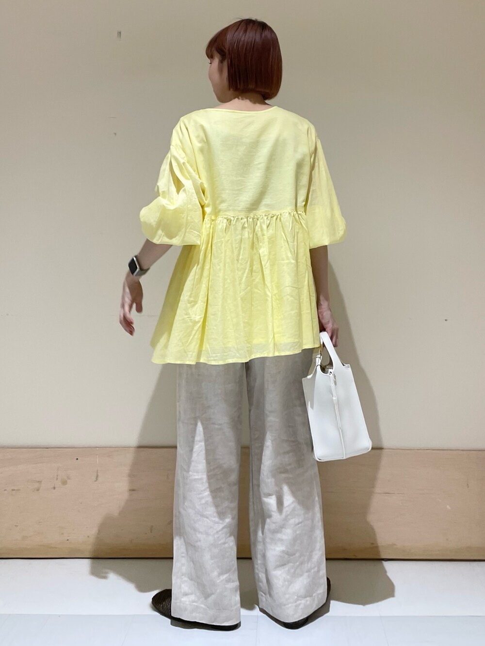 ベージュ系のその他パンツ、イエロー系のシャツ/ブラウス、ホワイト系のトートバッグを着用したレディースの春コーディネートの7枚目の写真