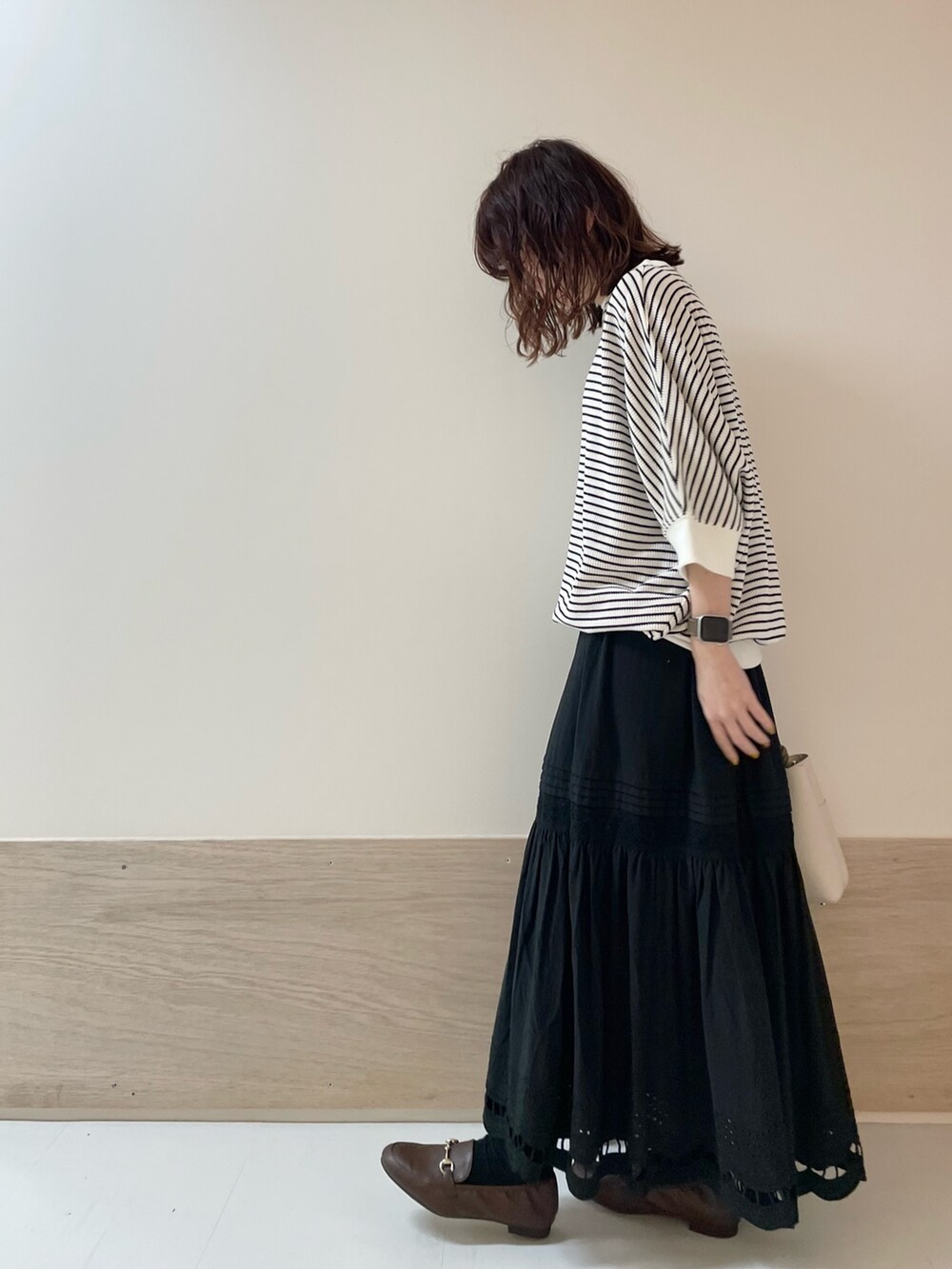 ブラウン系のローファー、ブラック系のスカート、ホワイト系のTシャツ/カットソーを着用したレディースの春コーディネートの3枚目の写真