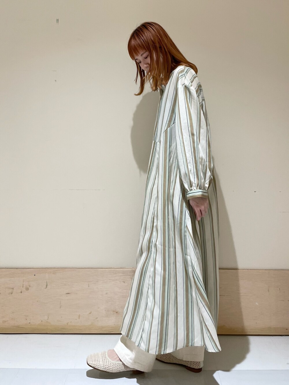 グリーン系のワンピース、ホワイト系のパンプス、ブラック系のショルダーバッグを着用したレディースの春コーディネートの4枚目の写真