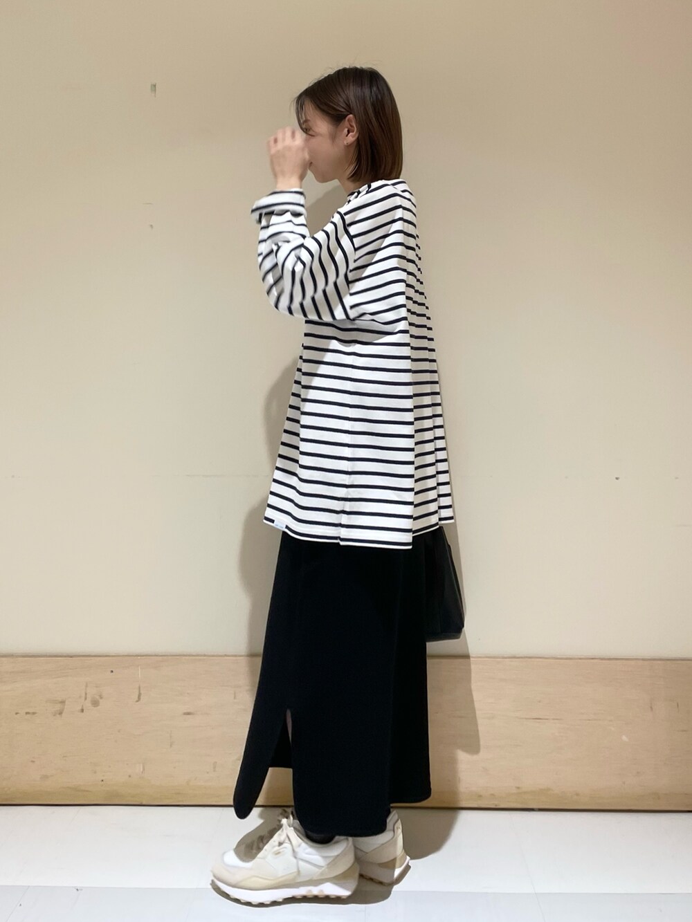 ブルー系のTシャツ/カットソー、ブラック系のスカート、ブラック系のトートバッグを着用したレディースの秋コーディネートの4枚目の写真