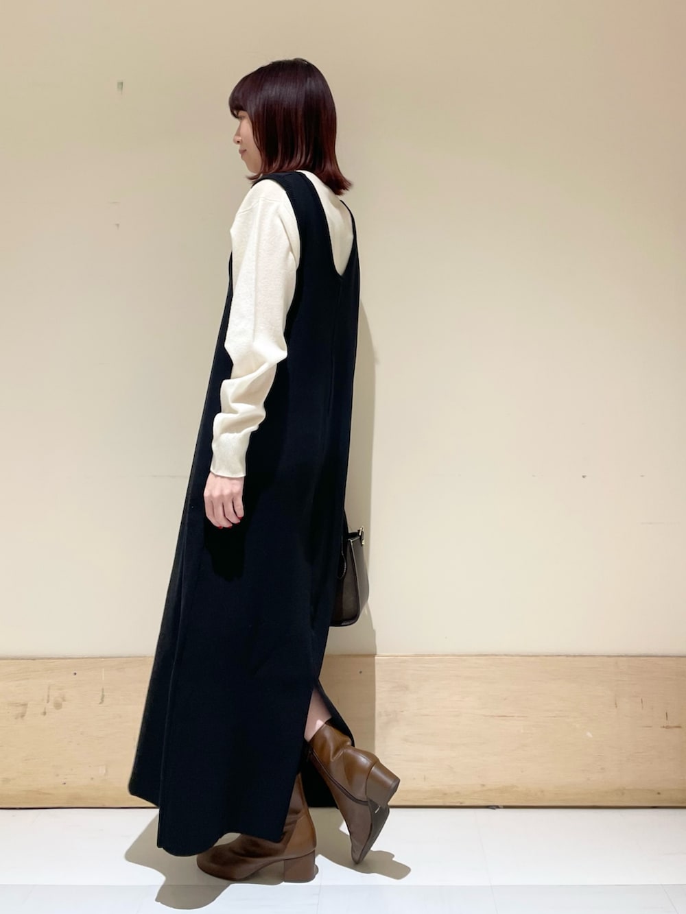 ブラック系のワンピース、ホワイト系のニット/セーターを着用したレディースの冬コーディネートの5枚目の写真
