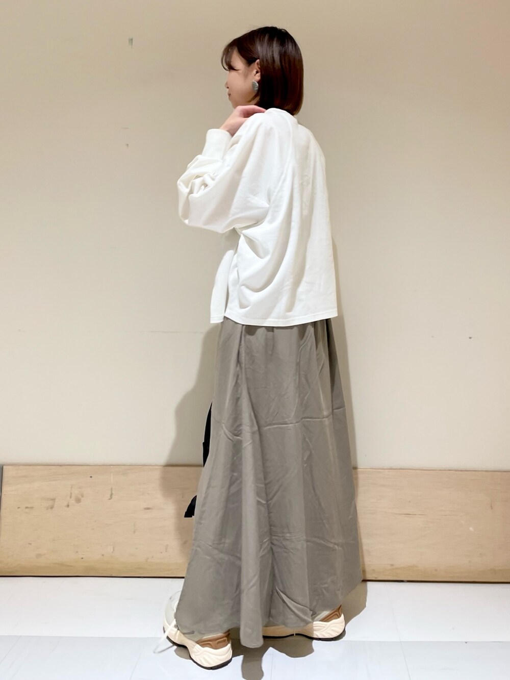 ホワイト系のTシャツ/カットソー、グリーン系のスカート、グレー系のスニーカーを着用したレディースの夏コーディネートの5枚目の写真