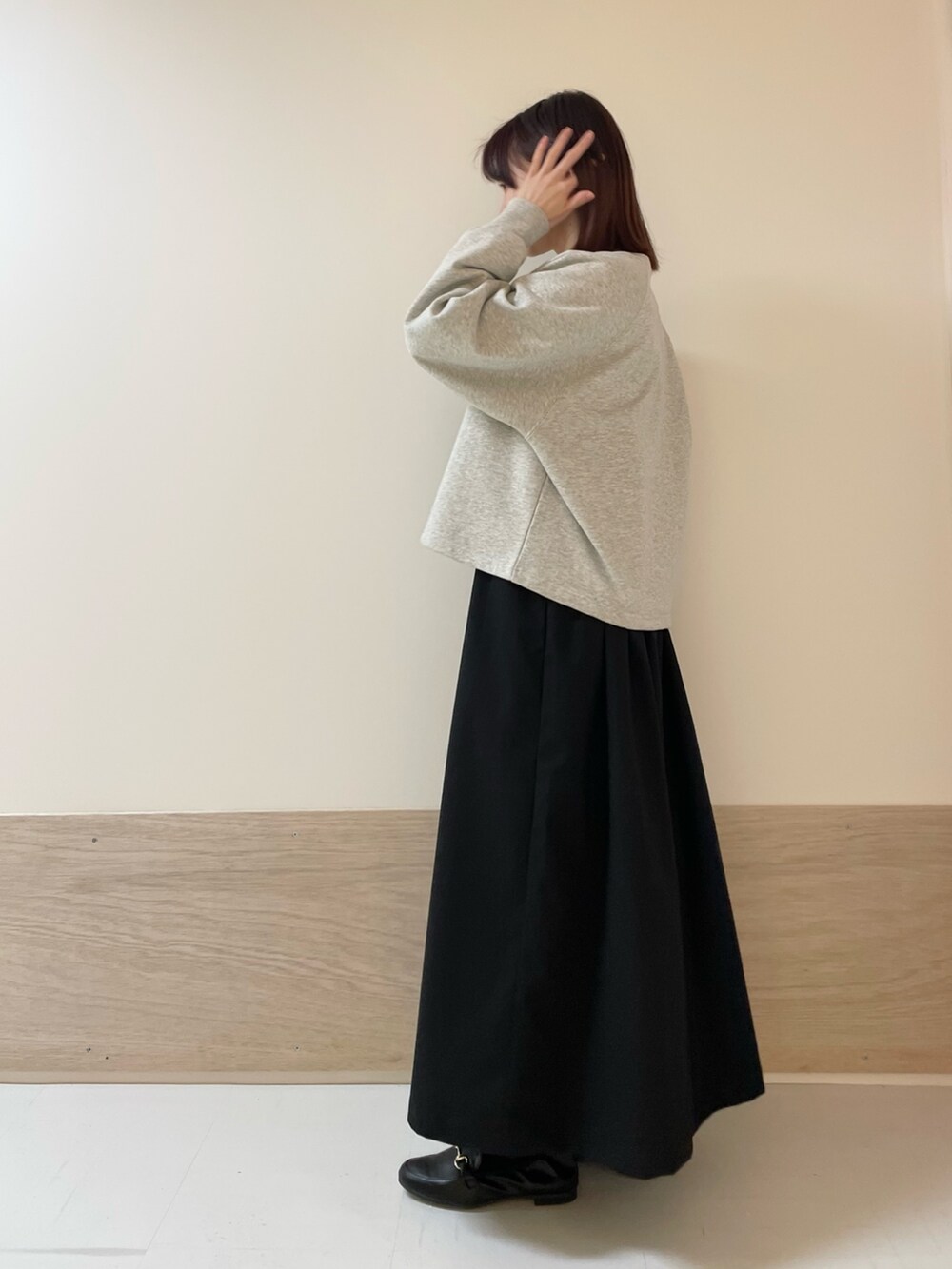 グレー系のカーディガン/ボレロ、イエロー系のニット/セーター、ブラック系のワンピースを着用したレディースの春コーディネートの4枚目の写真