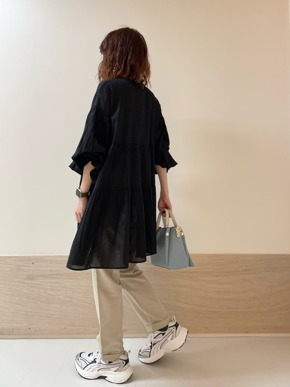 ブラック系のチュニック、ベージュ系のその他パンツを着用したレディースの春コーディネートの6枚目の写真