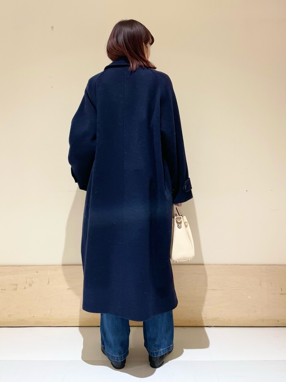 ブルー系のデニムパンツ、ピンク系のニット/セーター、ブルー系のステンカラーコートを着用したレディースの冬コーディネートの7枚目の写真