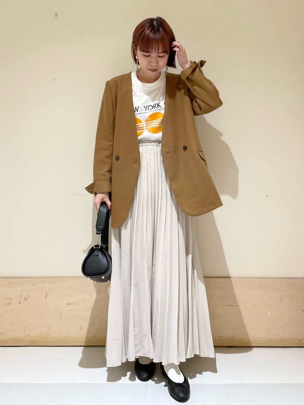 ベージュ系のノーカラージャケット、ブラック系のショルダーバッグ、ブラック系のバレエシューズを着用したレディースの春コーディネートの3枚目の写真