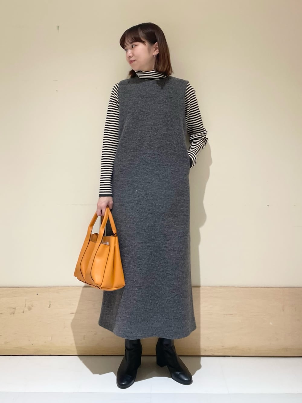 ホワイト系のニット/セーター、グレー系のワンピースを着用したレディースの冬コーディネートの2枚目の写真