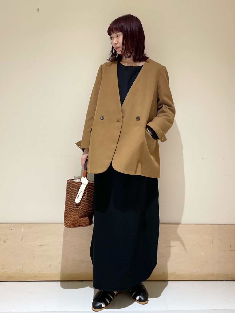 ブラック系のワンピース、ベージュ系のノーカラージャケット、ブラック系のサンダルを着用したレディースの春コーディネートの3枚目の写真