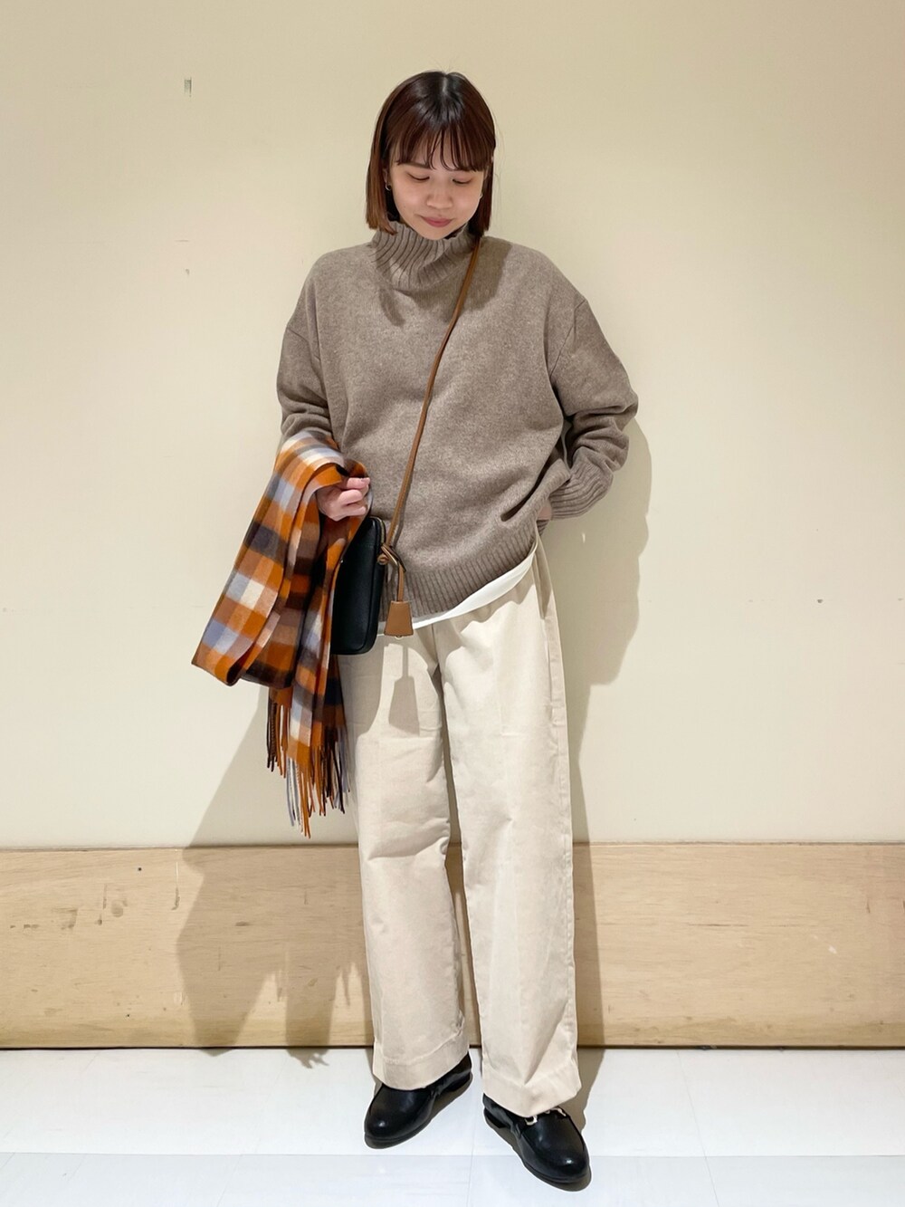 ホワイト系のTシャツ/カットソー、ブラウン系のニット/セーター、ベージュ系のその他パンツを着用したレディースの冬コーディネートの3枚目の写真