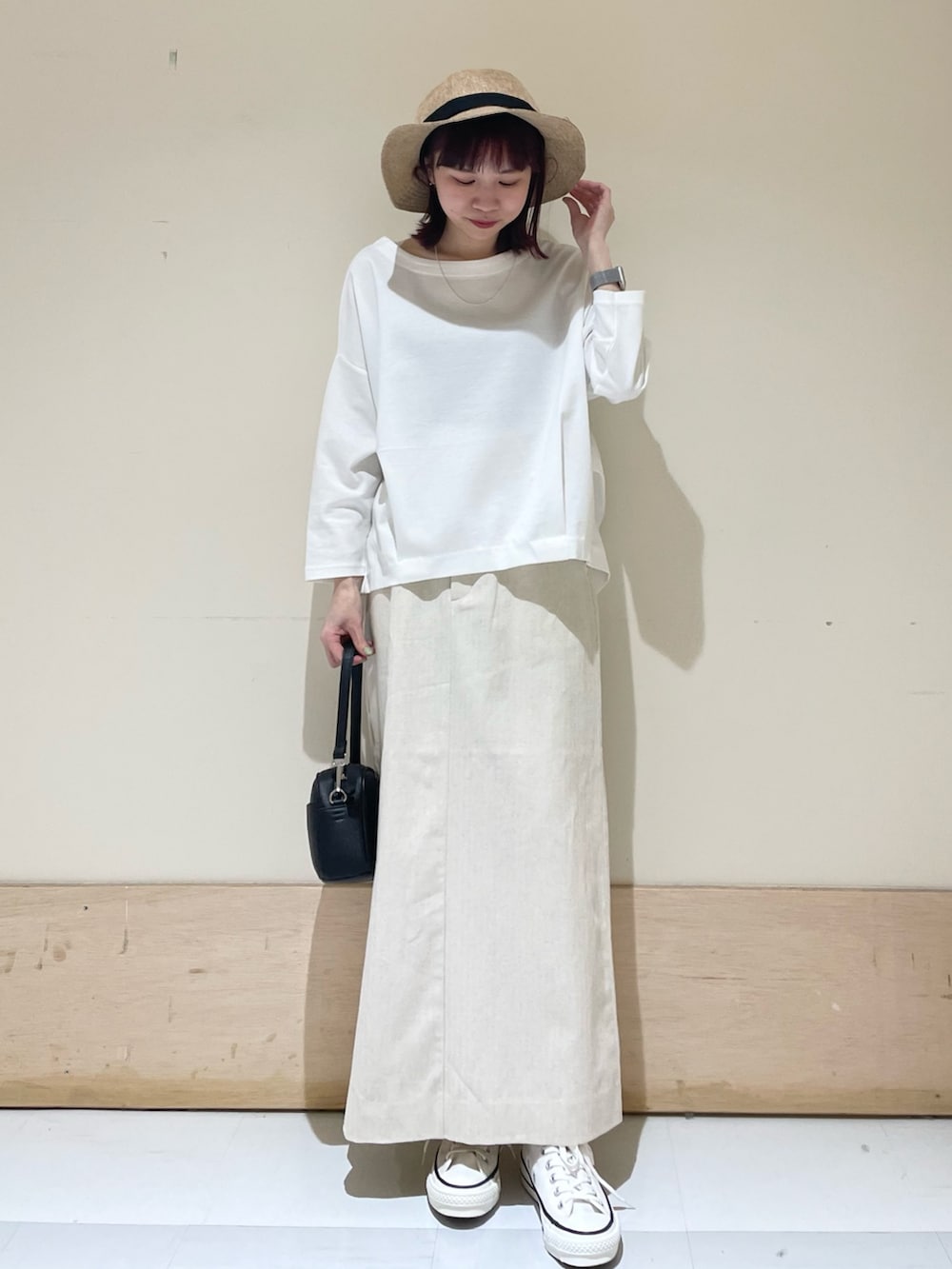 ホワイト系のTシャツ/カットソー、ホワイト系のスニーカー、ブラック系のショルダーバッグを着用したレディースの春コーディネートの2枚目の写真