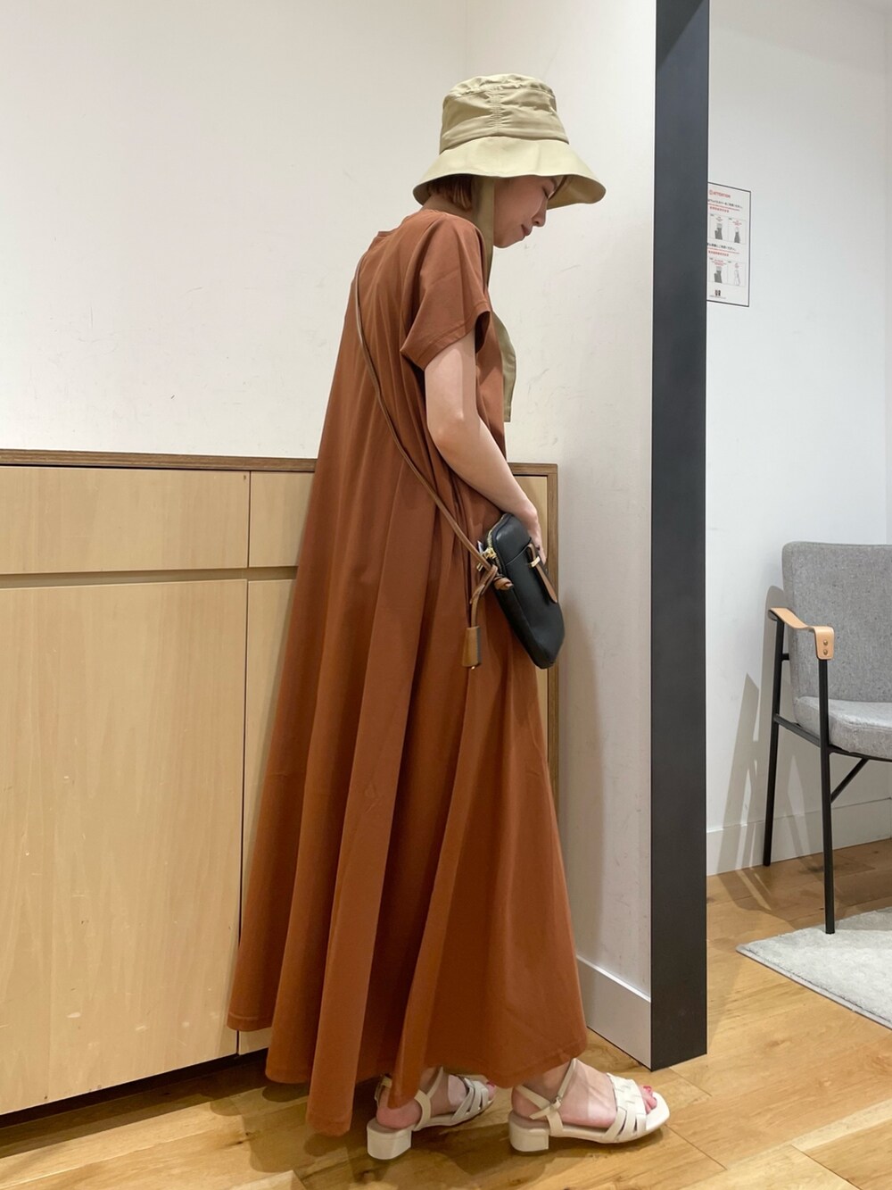 ホワイト系のサンダル、ブラウン系のワンピース、ブラック系のショルダーバッグを着用したレディースの夏コーディネートの5枚目の写真