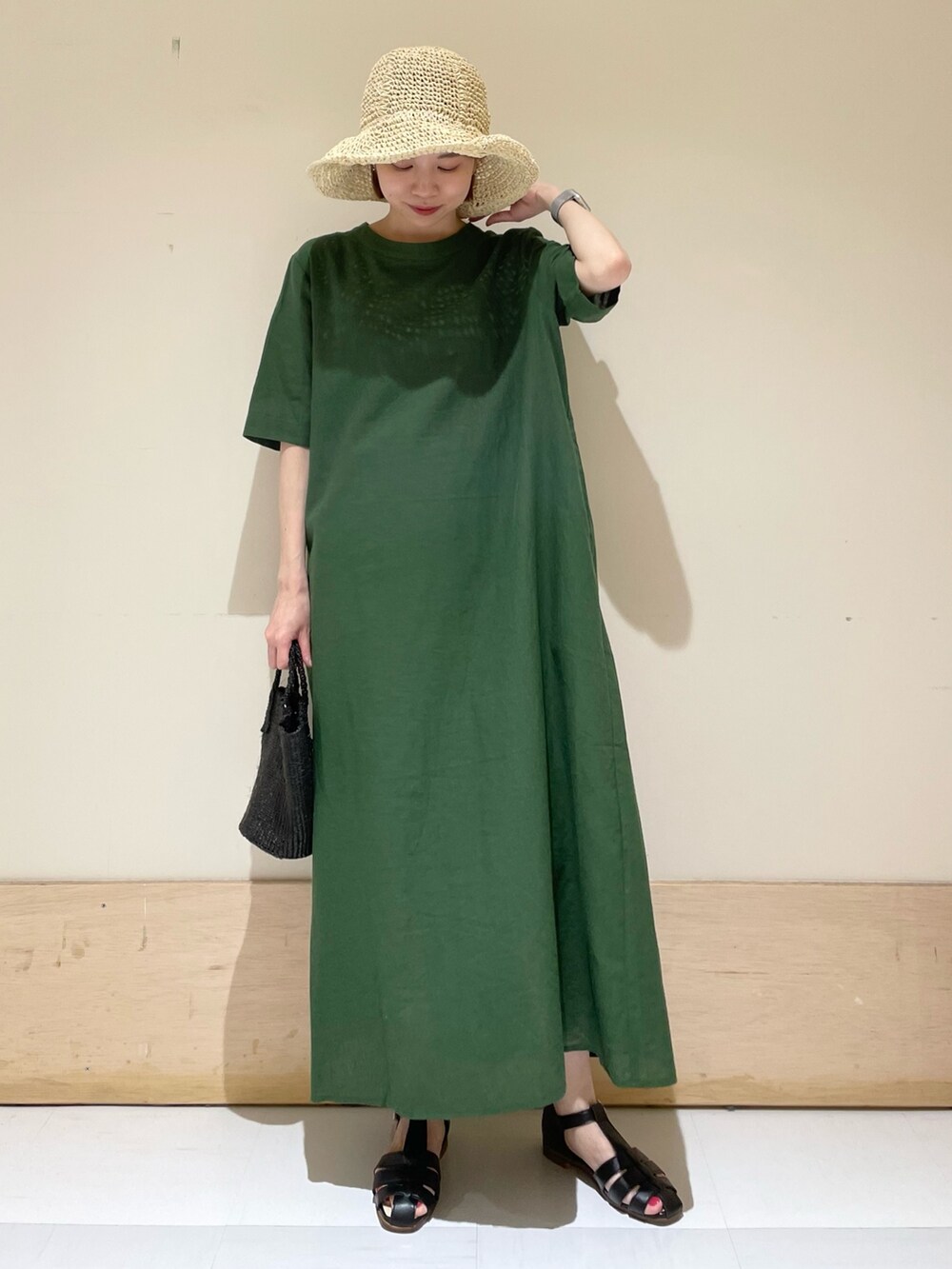 グリーン系のワンピース、ブラック系のサンダル、ブラック系のハンドバッグを着用したレディースの春コーディネートの10枚目の写真