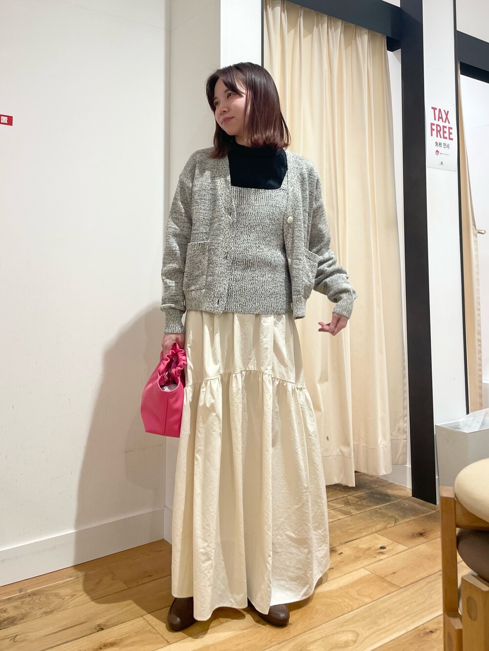 ブルー系のニット/セーター、ブルー系のカーディガン/ボレロ、ホワイト系のスカートを着用したレディースの春コーディネートの2枚目の写真