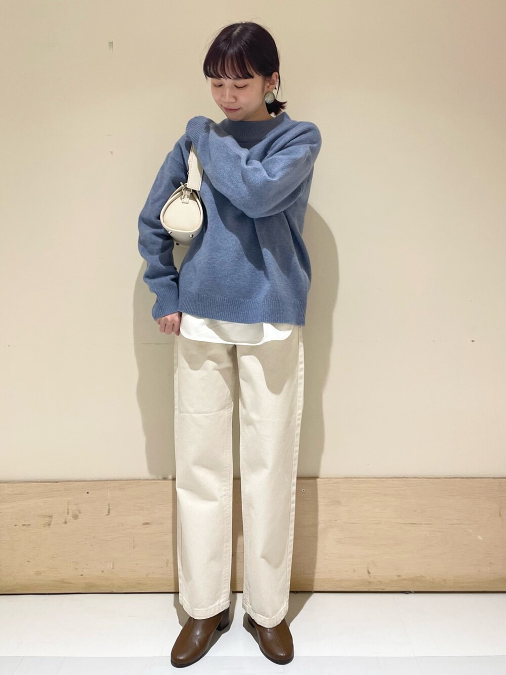 ベージュ系のデニムパンツ、ブルー系のニット/セーター、ホワイト系のショルダーバッグを着用したレディースの冬コーディネートの8枚目の写真