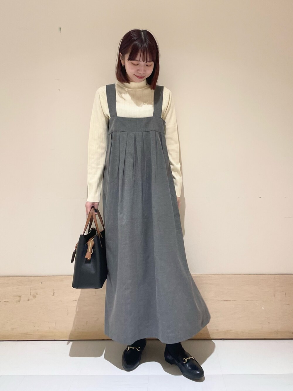 グレー系のワンピース、ホワイト系のニット/セーターを着用したレディースの冬コーディネートの3枚目の写真