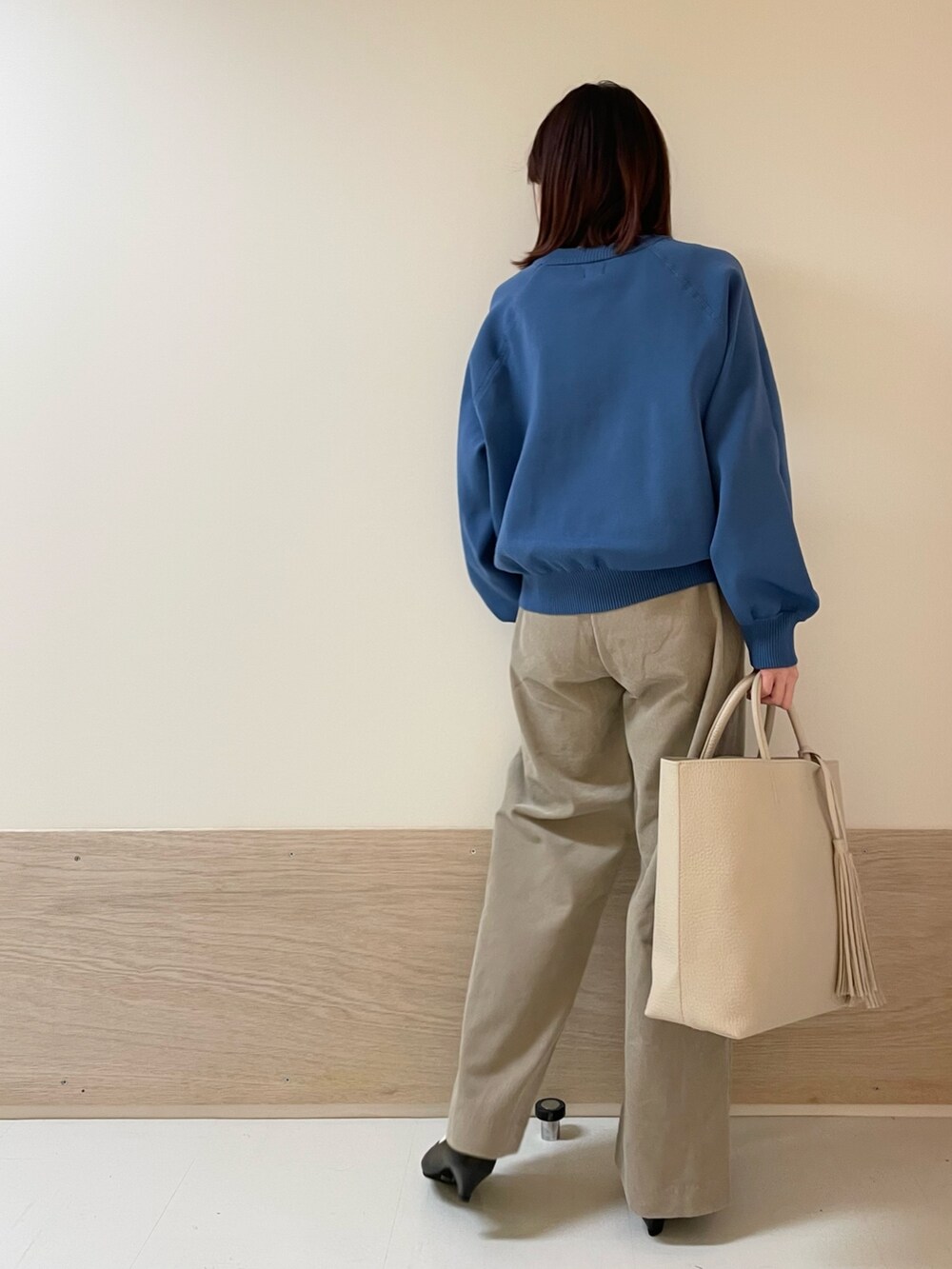 ブルー系のニット/セーター、ベージュ系のその他パンツ、ブラック系のパンプスを着用したレディースの冬コーディネートの6枚目の写真