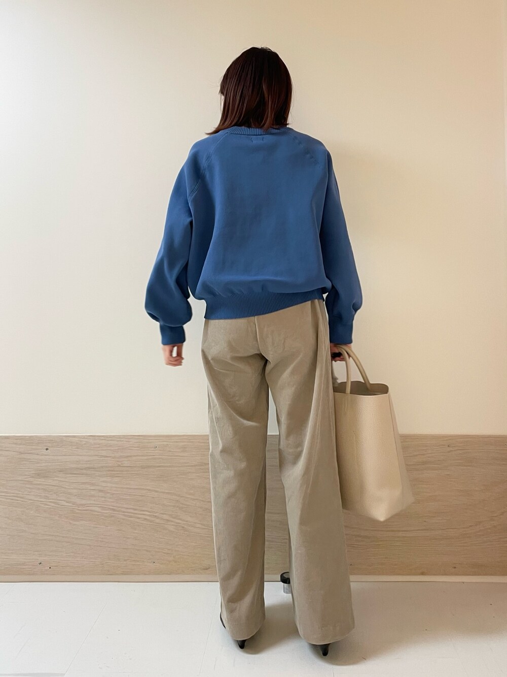 ブルー系のニット/セーター、ベージュ系のその他パンツ、ブラック系のパンプスを着用したレディースの冬コーディネートの5枚目の写真