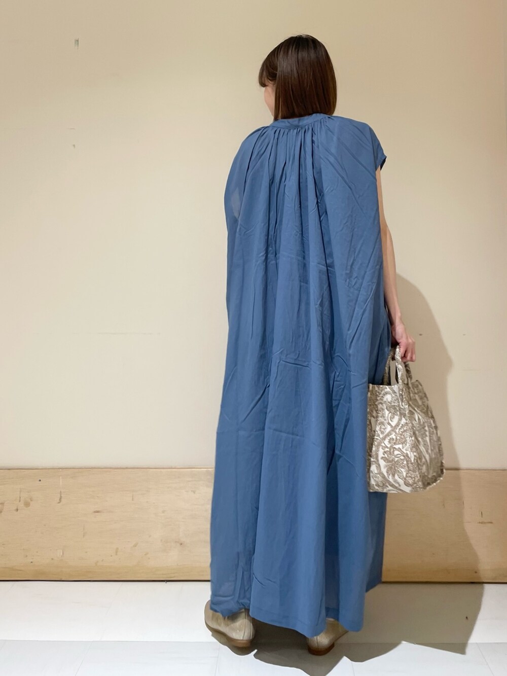 ブルー系のワンピース、ベージュ系のトートバッグ、ゴールド系のパンプスを着用したレディースの夏コーディネートの7枚目の写真