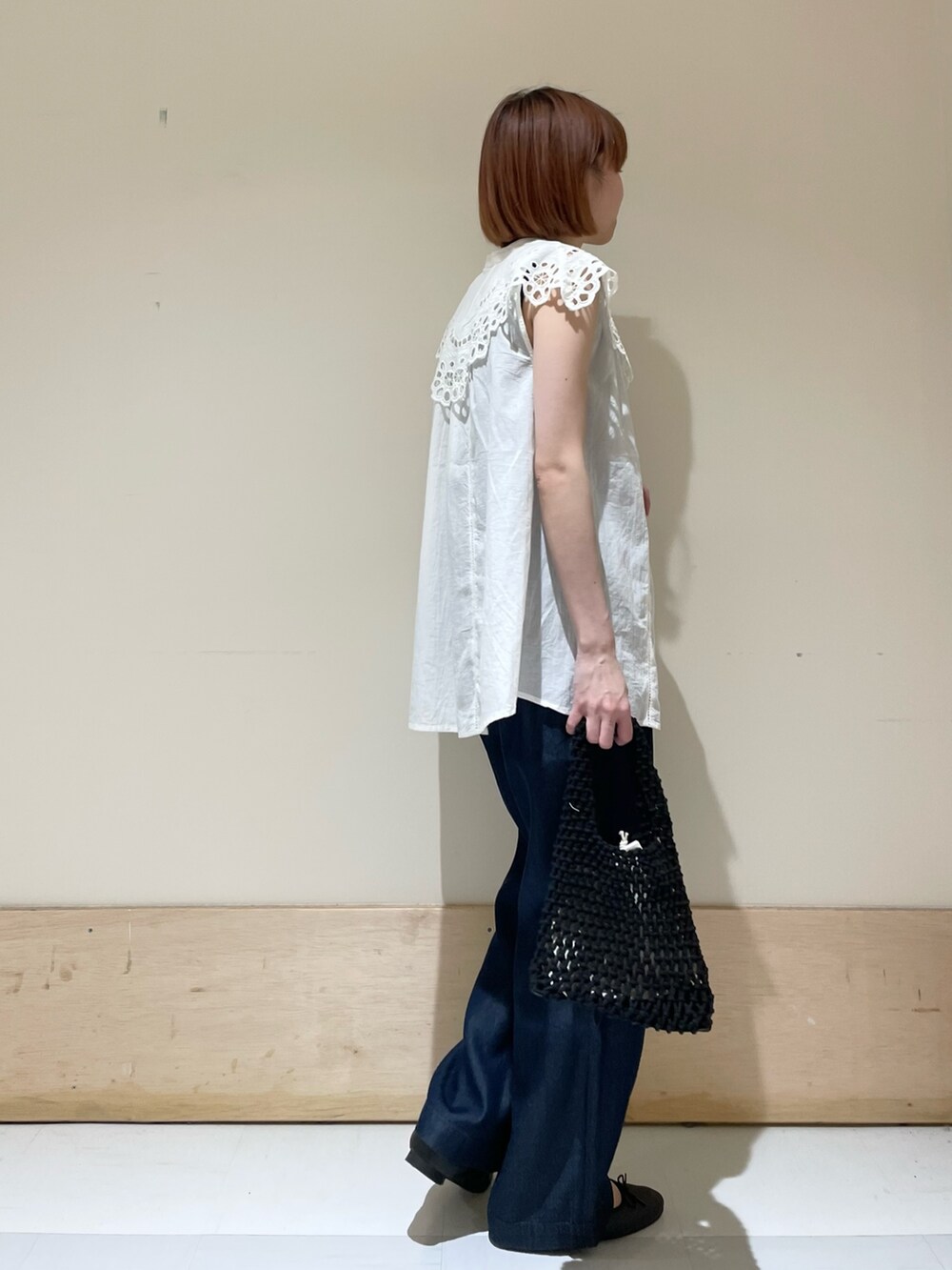 ホワイト系のシャツ/ブラウス、ブルー系のその他パンツ、ブラック系のハンドバッグを着用したレディースの春コーディネートの4枚目の写真