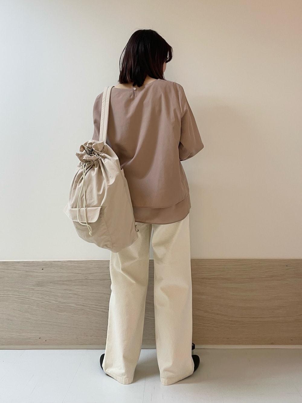 ベージュ系のデニムパンツ、ブラック系のパンプス、ピンク系のバックパック/リュックを着用したレディースの春コーディネートの6枚目の写真