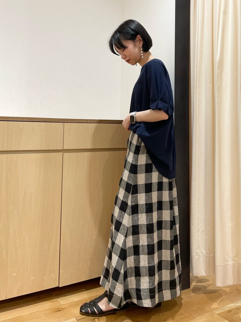 ブルー系のTシャツ/カットソー、ブラック系のスカート、ベージュ系のかごバッグを着用したレディースの夏コーディネートの5枚目の写真