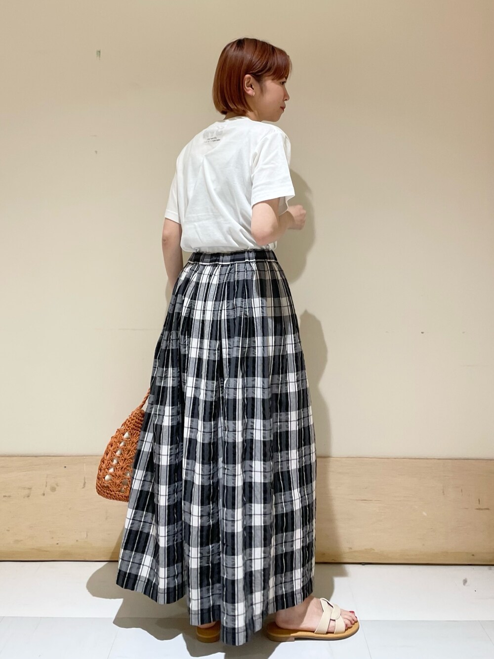 ブラック系のスカート、グレー系のTシャツ/カットソー、ブラウン系のかごバッグを着用したレディースの春コーディネートの7枚目の写真