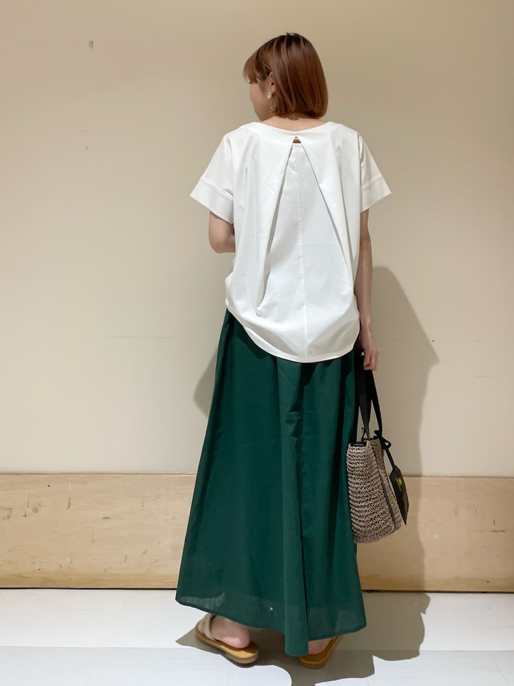 ホワイト系のTシャツ/カットソー、グレー系のトートバッグ、グリーン系のスカートを着用したレディースの夏コーディネートの8枚目の写真