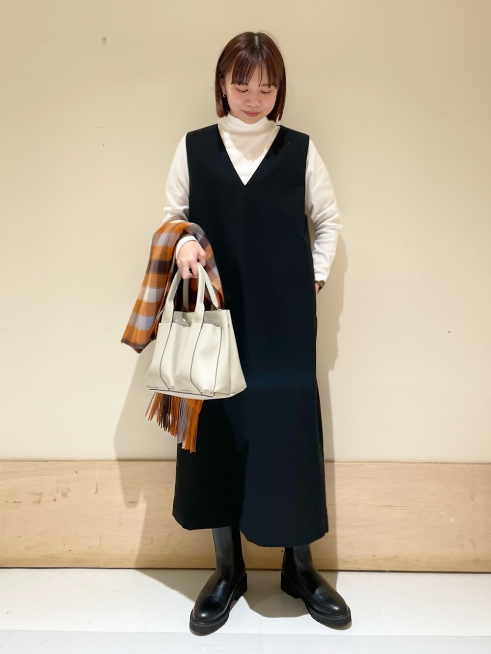 ブラック系のワンピース、ホワイト系のTシャツ/カットソー、ホワイト系のトートバッグを着用したレディースの秋コーディネートの2枚目の写真