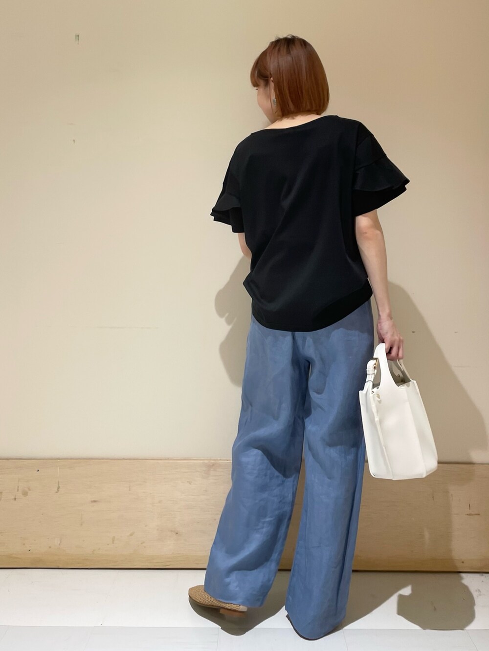 ブラック系のTシャツ/カットソー、ホワイト系のトートバッグ、ブルー系のその他パンツを着用したレディースの春コーディネートの7枚目の写真