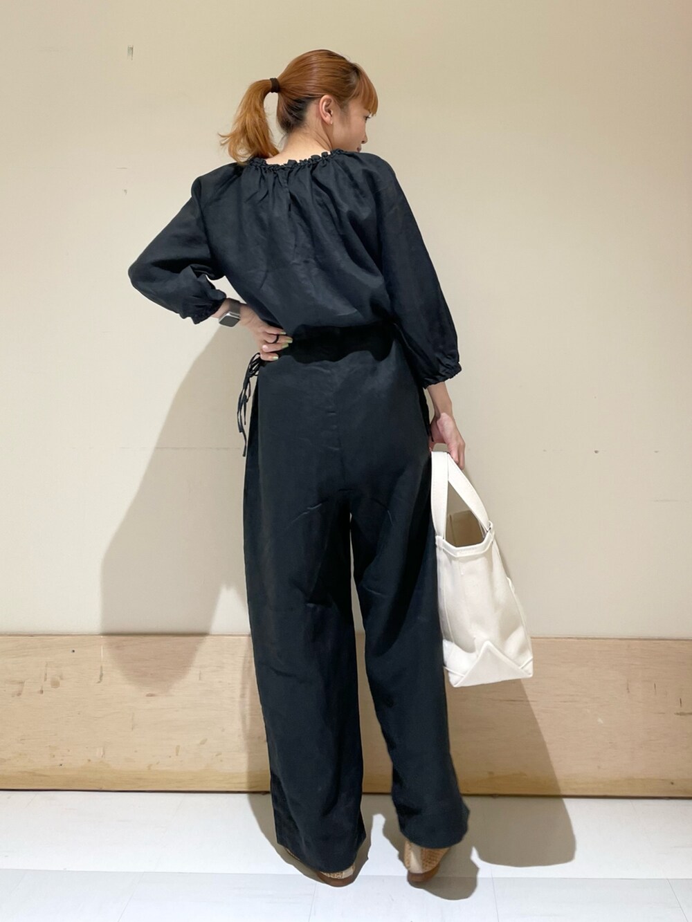 ブラック系のサロペット/オーバーオール、ベージュ系のバレエシューズ、ホワイト系のトートバッグを着用したレディースの春コーディネートの7枚目の写真