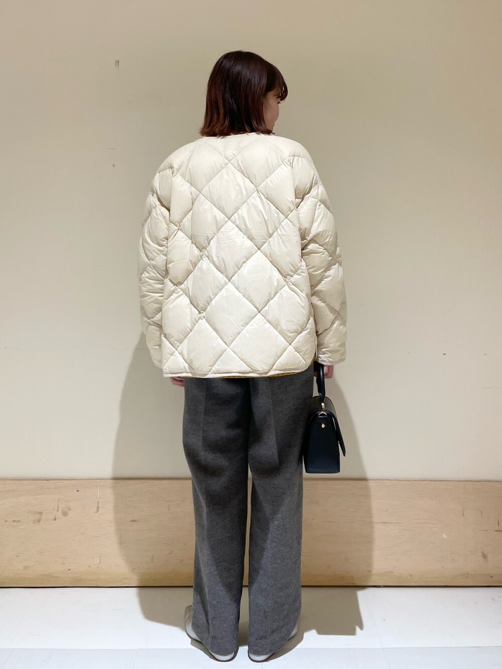 イエロー系のニット/セーター、グレー系のその他パンツ、ブラック系のショルダーバッグを着用したレディースの秋コーディネートの6枚目の写真