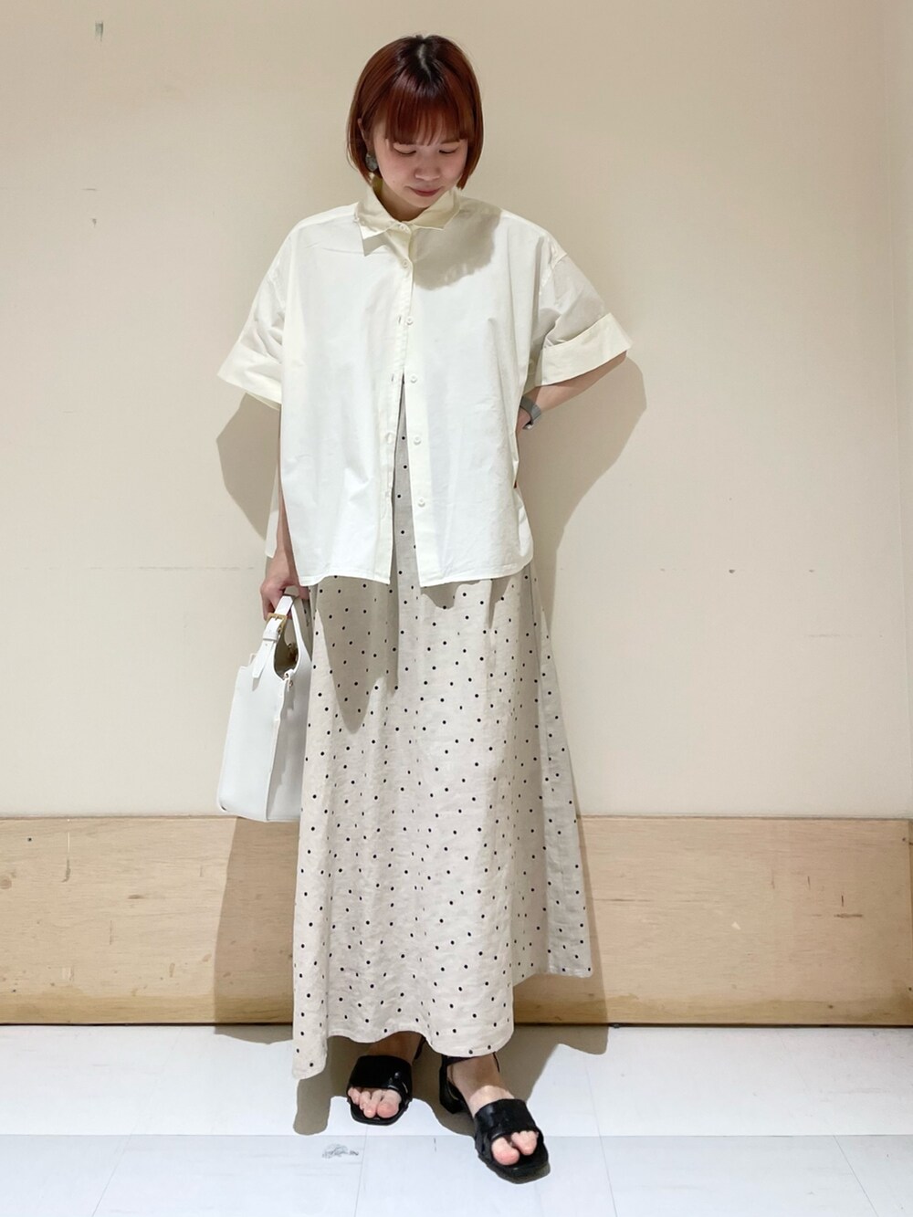 ベージュ系のワンピース、ホワイト系のトートバッグ、ホワイト系のシャツ/ブラウスを着用したレディースの春コーディネートの3枚目の写真