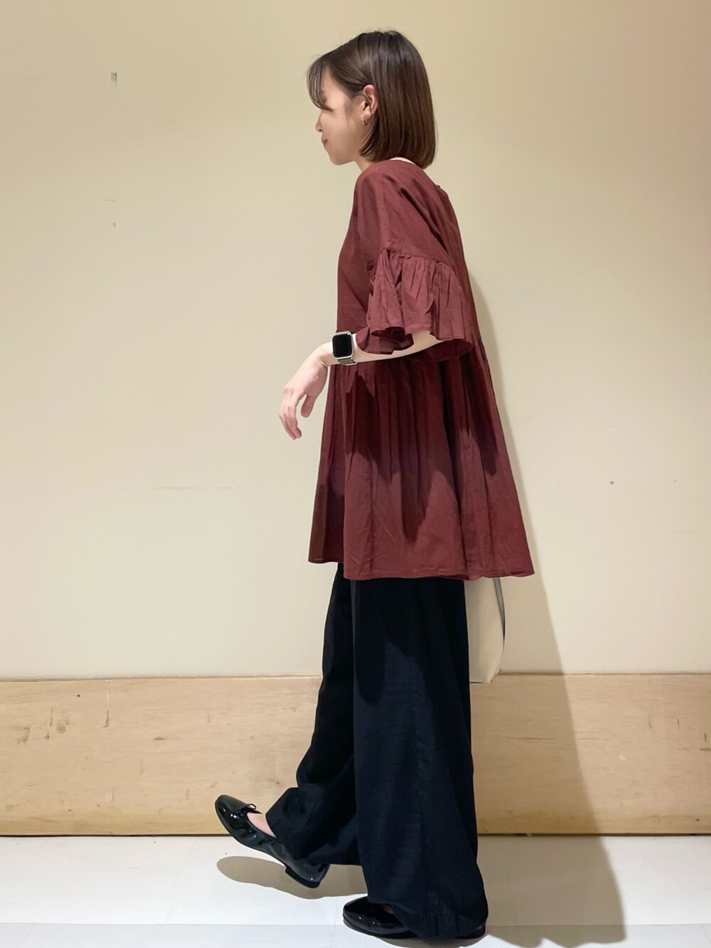 レッド系のシャツ/ブラウス、ブラック系のその他パンツ、ホワイト系のハンドバッグを着用したレディースの秋コーディネートの4枚目の写真