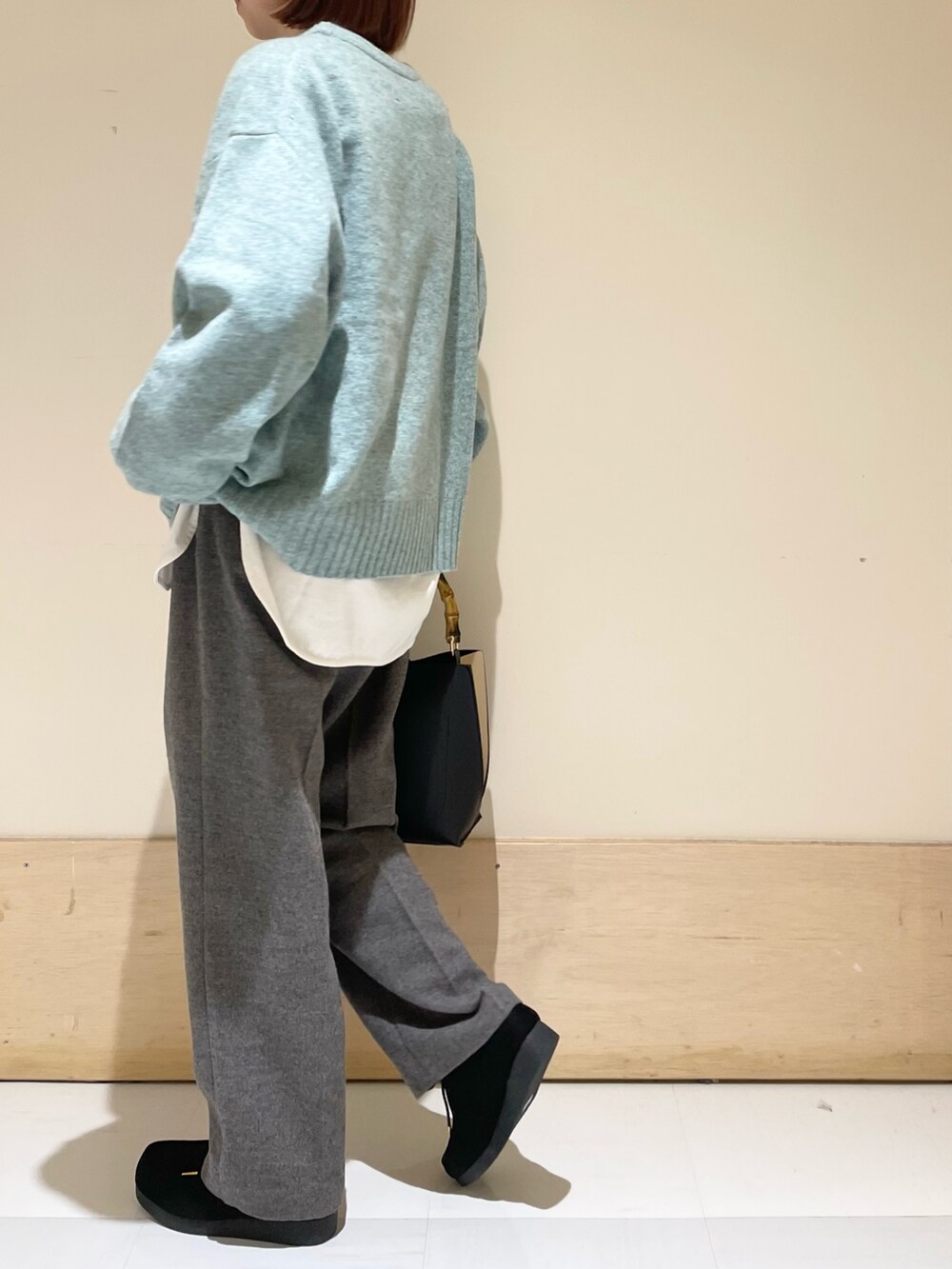 グリーン系のニット/セーター、ホワイト系のTシャツ/カットソー、グレー系のその他パンツを着用したレディースの冬コーディネートの4枚目の写真