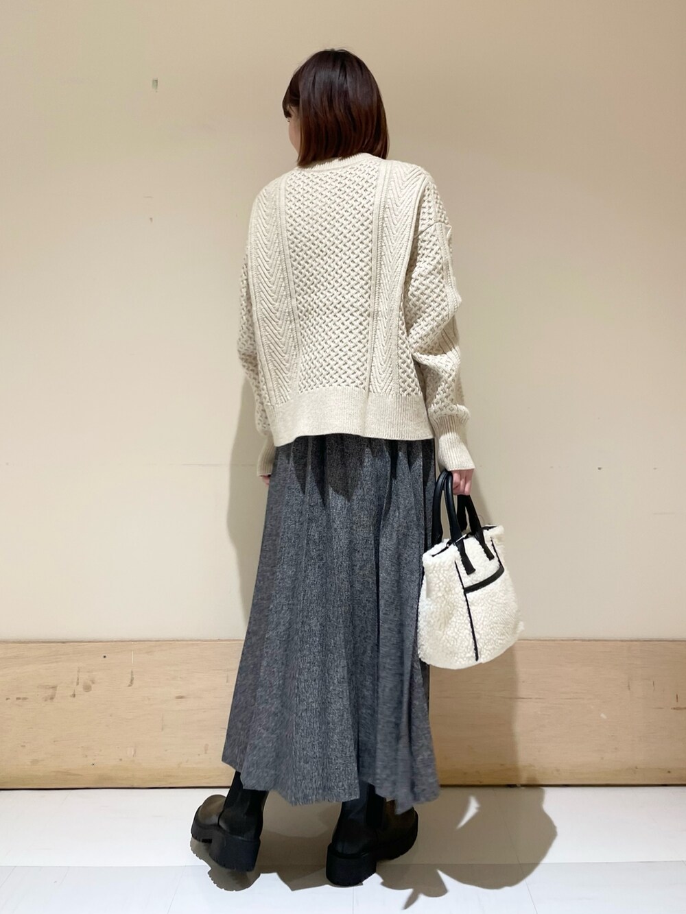 ホワイト系のカーディガン/ボレロ、ブルー系のスカート、ホワイト系のショルダーバッグを着用したレディースの冬コーディネートの6枚目の写真