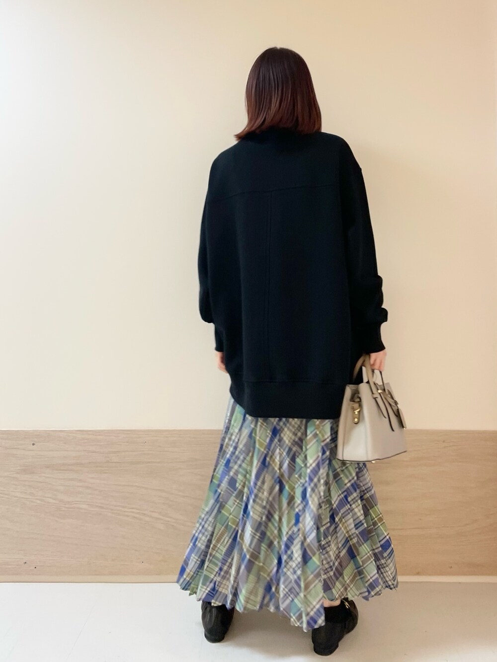 グリーン系のスカート、ブラック系のスウェットを着用したレディースの春コーディネートの6枚目の写真