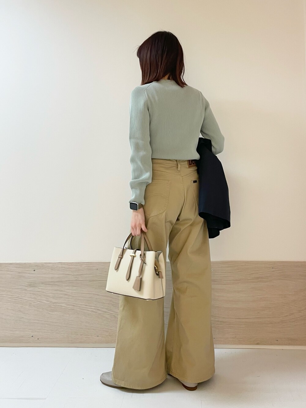 ブルー系のトレンチコート、グリーン系のニット/セーター、ベージュ系のその他パンツを着用したレディースの春コーディネートの8枚目の写真